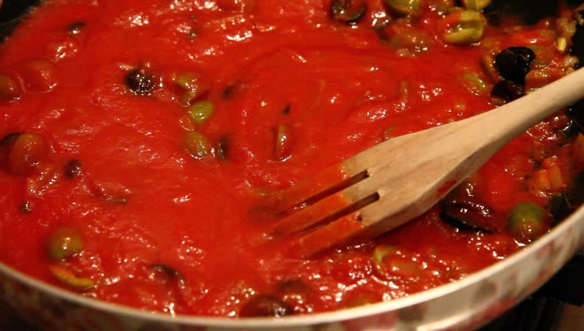 tomato sauce on fried onions and olives