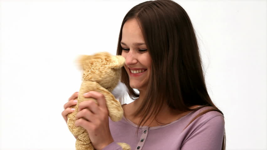 Beautiful woman playing with a teddy bear isolated on a white background