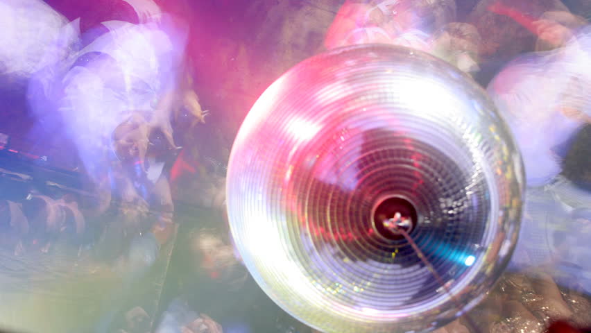 cool shot looking down onto a dancefloor in a club with a mirrorball and blurred dancers/crowd