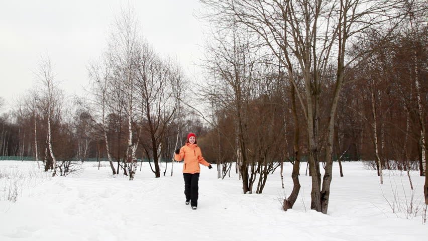 young happy woman in winter birch forest bouncing runs up to chamber