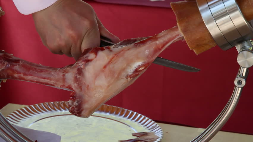 professional finishing a piece of jabugo ham
