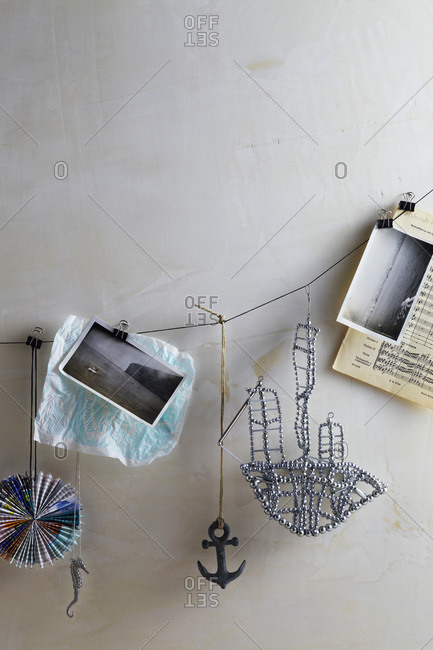 String of objects hanging: vintage photos, anchor, rhinestone boat