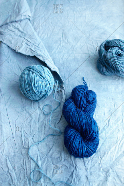 Still life of light and dark blue yarn on wrinkled light blue fabric