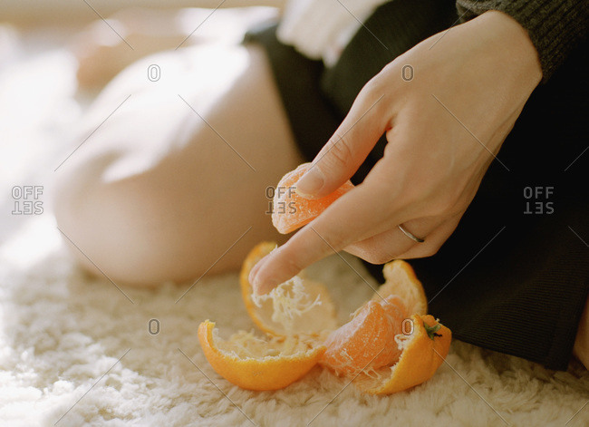 Woman's hand holding peeled tangerine