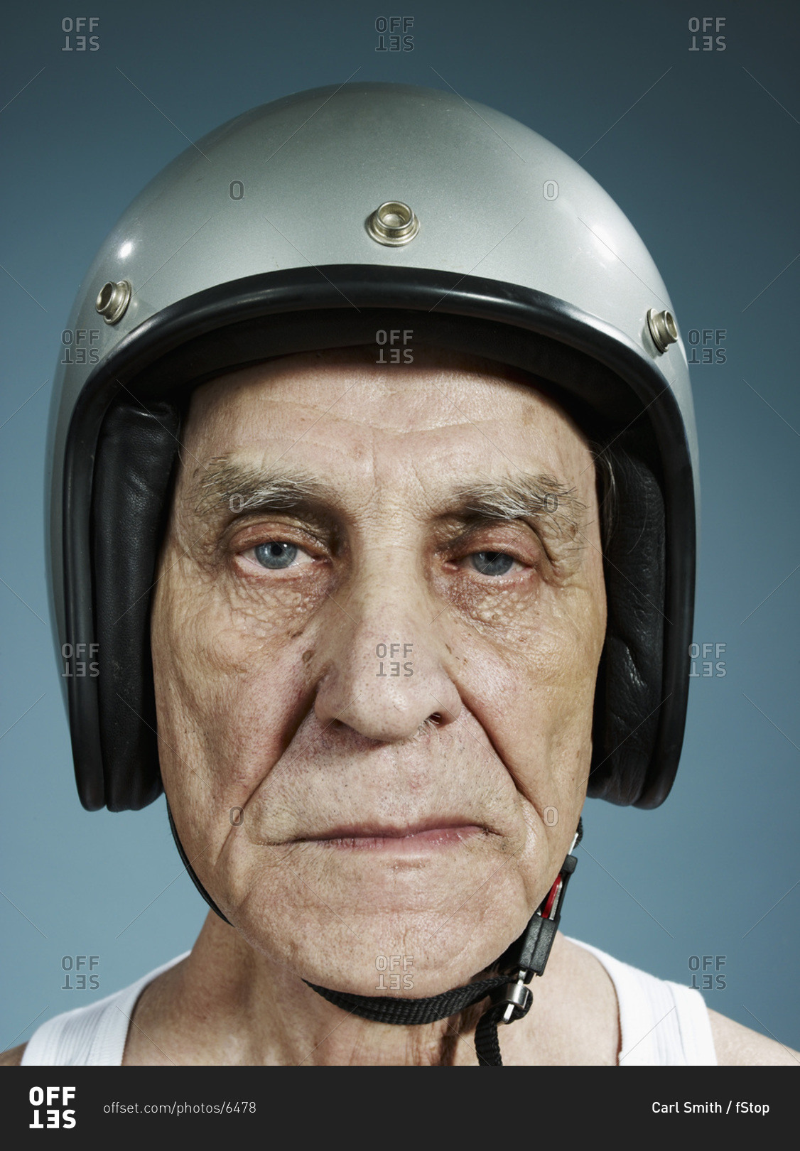 a-headshot-of-a-frowning-senior-man-wearing-a-crash-helmet-stock-photo