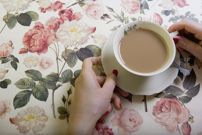 A cup of tea on a floral tablecloth