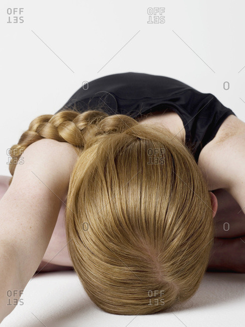 A young woman bending over and resting her head on the floor