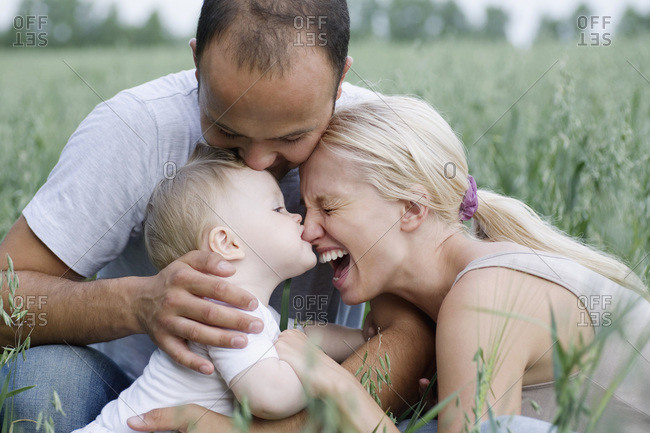 Two parents and their baby daughter in a field