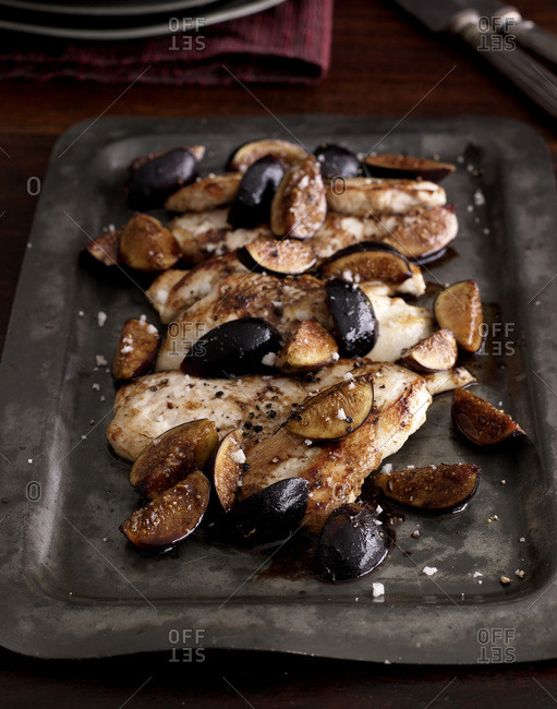 Roasted chicken breast and figs on square plate.