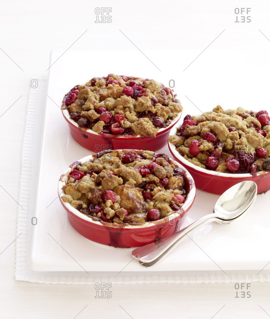 Three bowls of cherry cobblers with spoon.