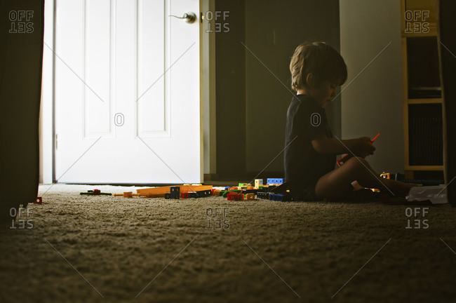 Young boy playing with building toys in a doorway