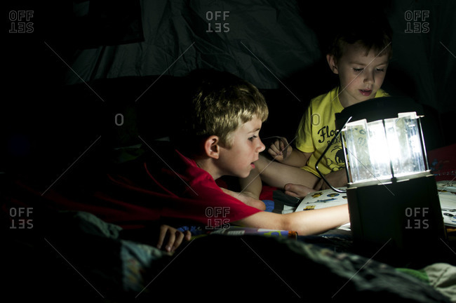 Two boys playing by the light of a lantern