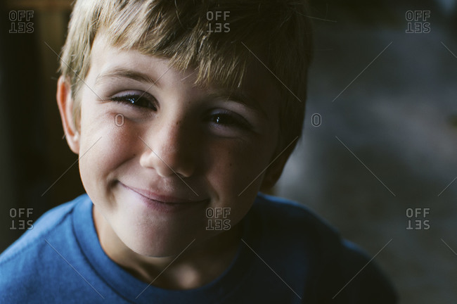 Close-up of young boy smiling with squinty eyes