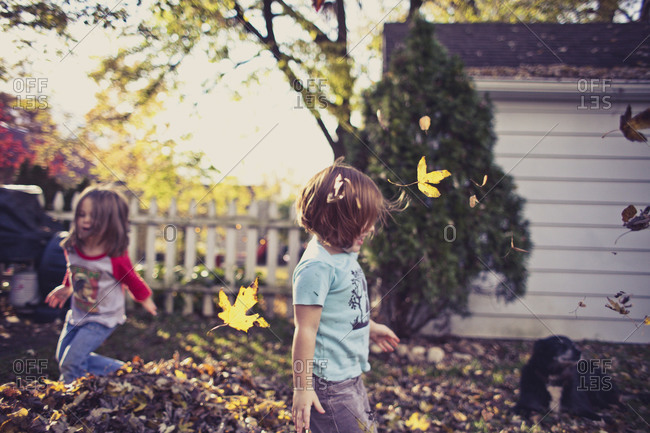 Children playing in leaves outside