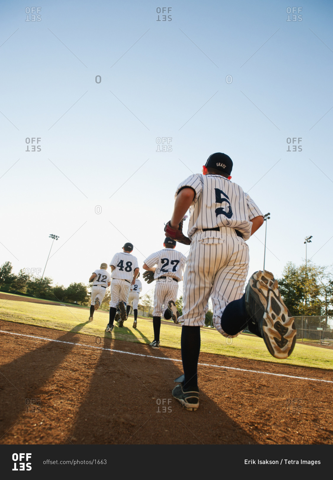 Baseball players (10-11) running on baseball diamond
