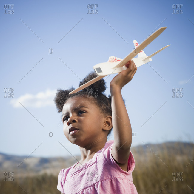 Young girl playing with toy airplane