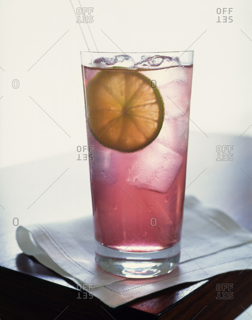 Cocktail with lime slice and ice cubes