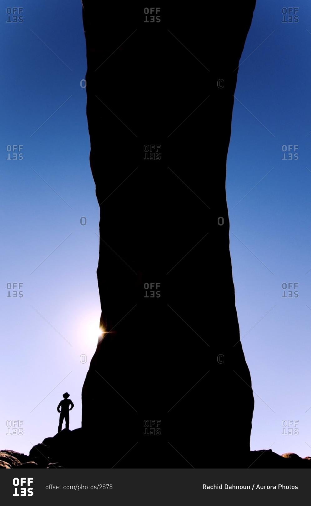A silhouette of a man standing under North Window Arch in Arches National Park, Utah