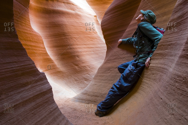 A female hiker takes a moment to enjoy Lower Antelope Canyon located outside of Page, AZ