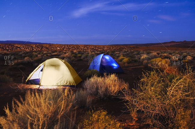 A pair of tents glow in the twilight in the campground at Sand Hollow State Park, Utah
