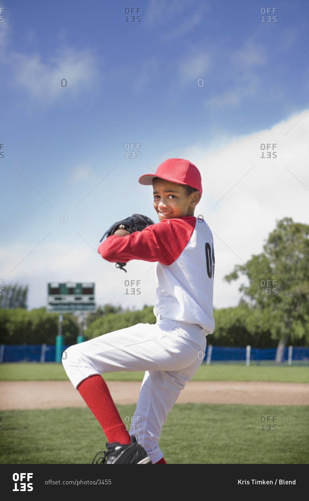 Mixed race boy pitching in baseball game