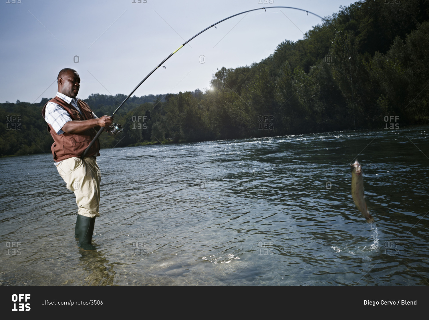 black-man-catching-fish-in-stream-stock-photo-offset