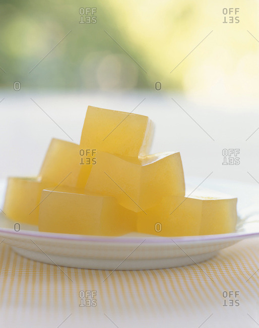 Peach jelly cubes on a white plate.