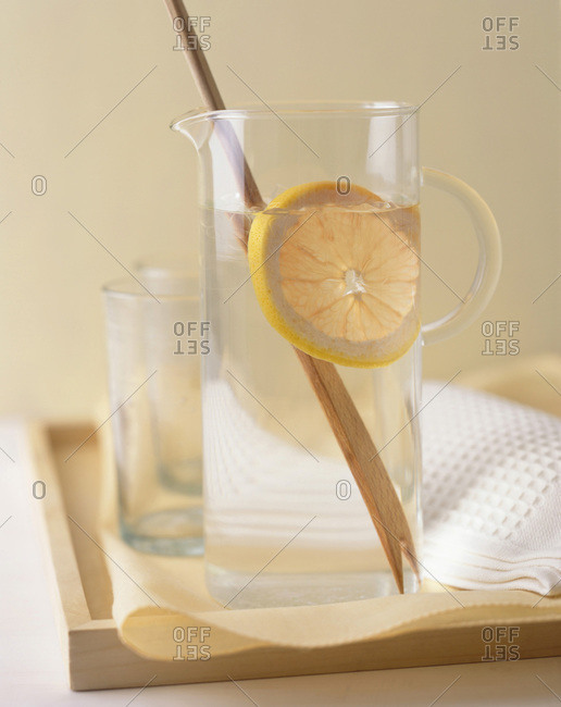 Mineral water with ice cubes and orange slice.