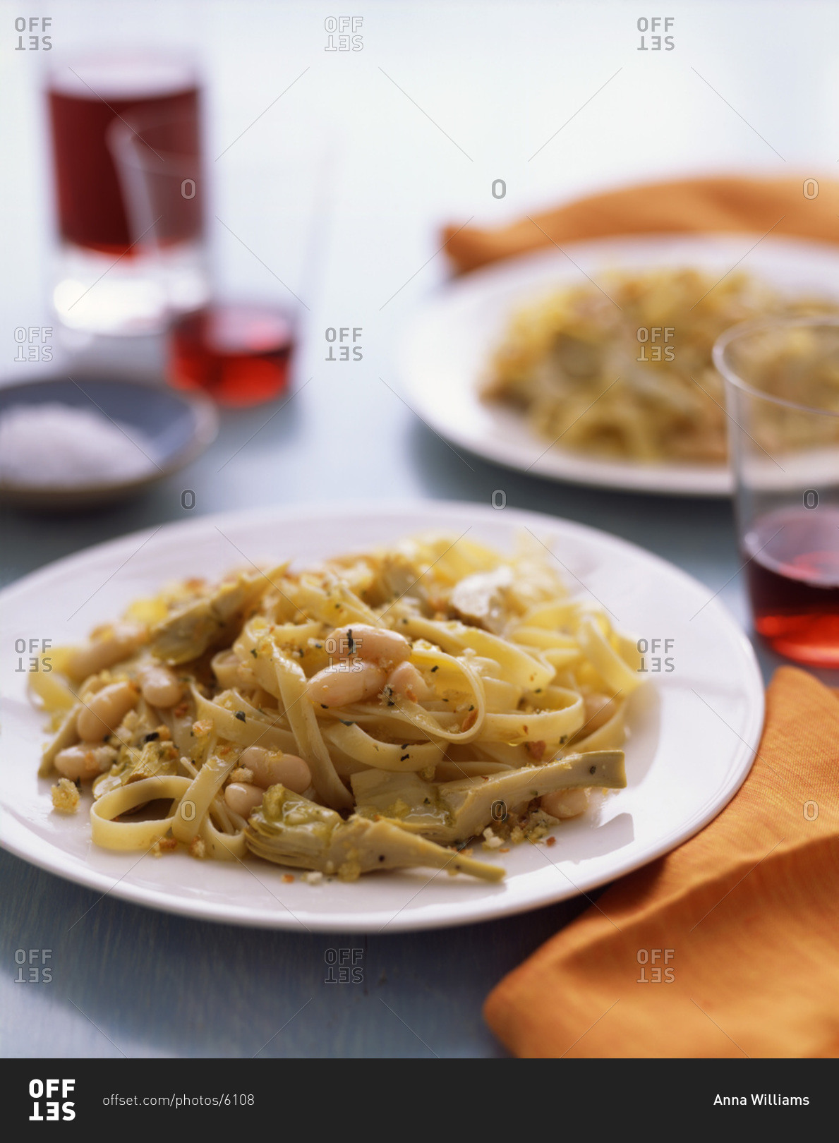 Spaghetti with bean and artichoke, seasoned with chopped nuts.