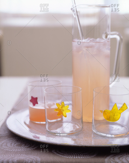 Lemonade with ice cubes and glasses with different labels.