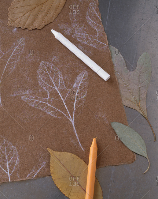 Making dried leaf patterns with crayon from above.