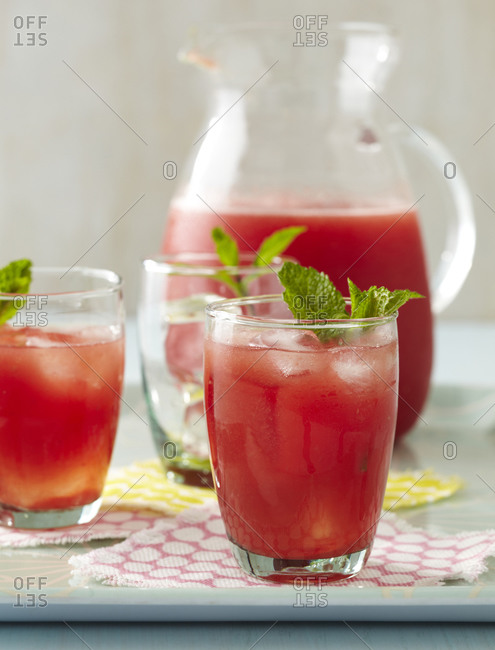 Fruit juice with ice cube and peppermint.