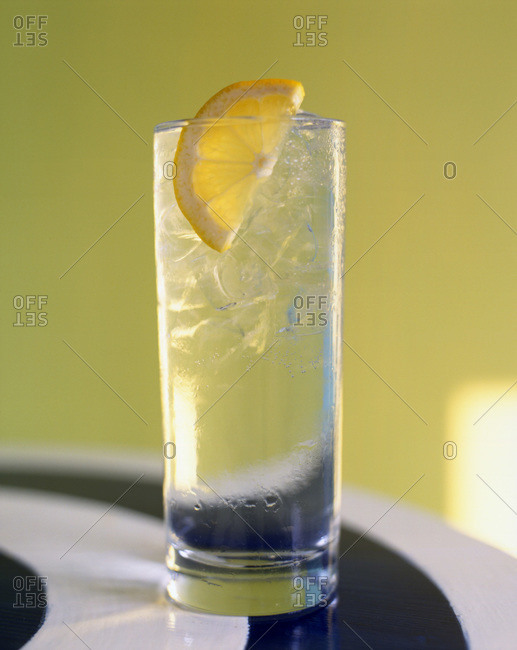 Cocktail with lemon slice and ice cubes
