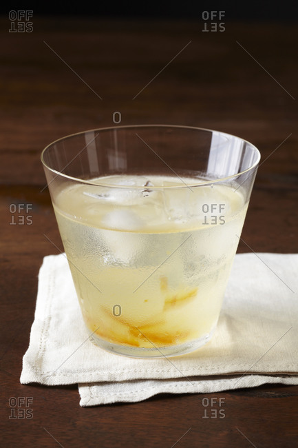Cocktail with lemon zest and ice cubes.
