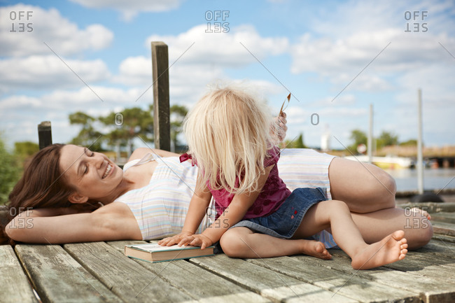 Mother and daughter resting on jetty