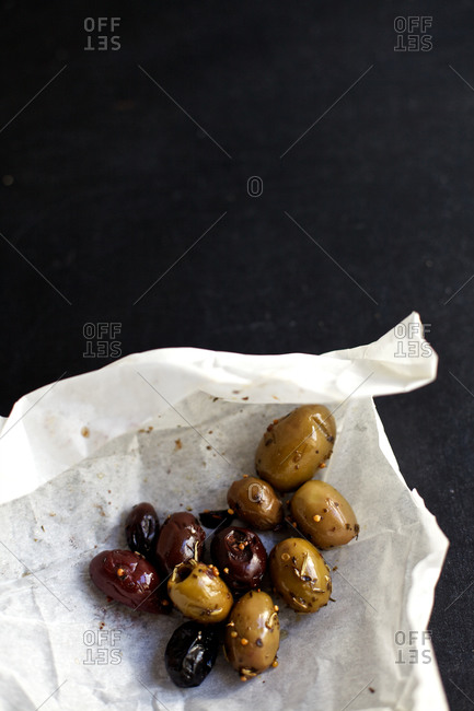 Marinated olives unwrapped on black background