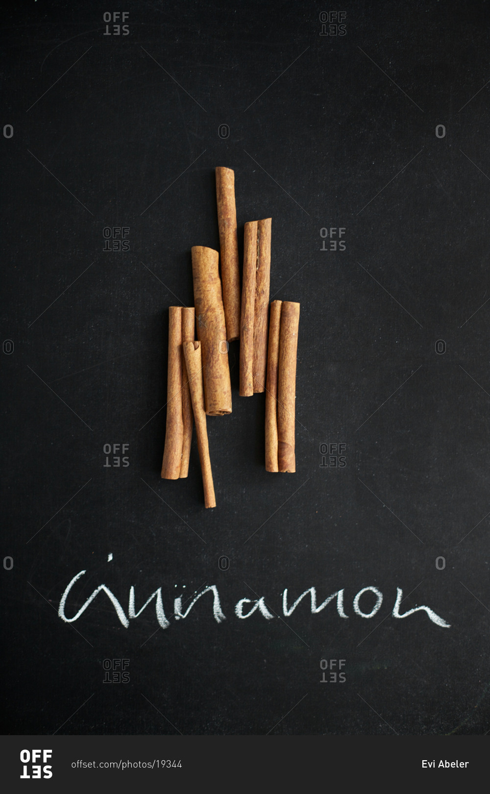 Cinnamon sticks arranged on chalk board with sign