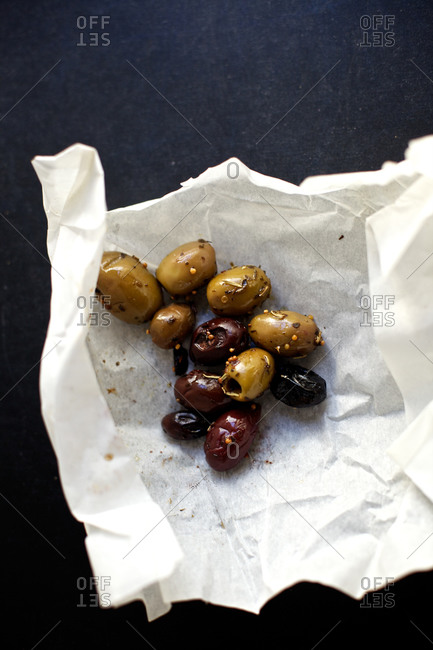 Marinated olives unwrapped on black background
