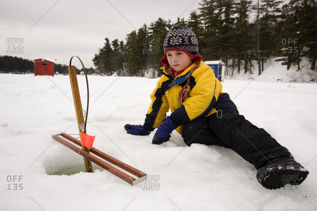 A boy checks traps, while ice fishing on Maine Lake in North Waterboro, Maine