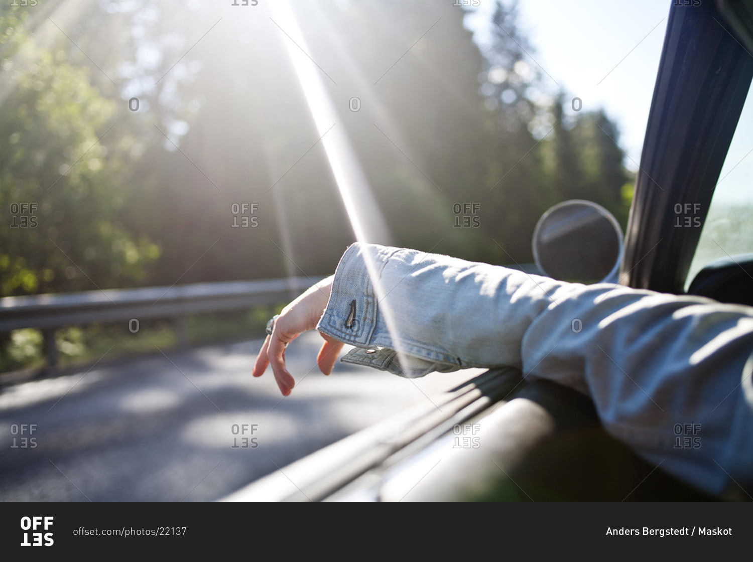 One hand out the car window on an empty highway stock photo OFFSET