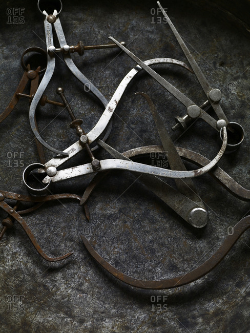 Vintage metal calipers on a gray surface.