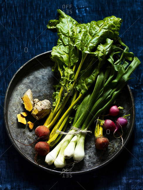 Raw, organic root vegetables on a vintage tray.