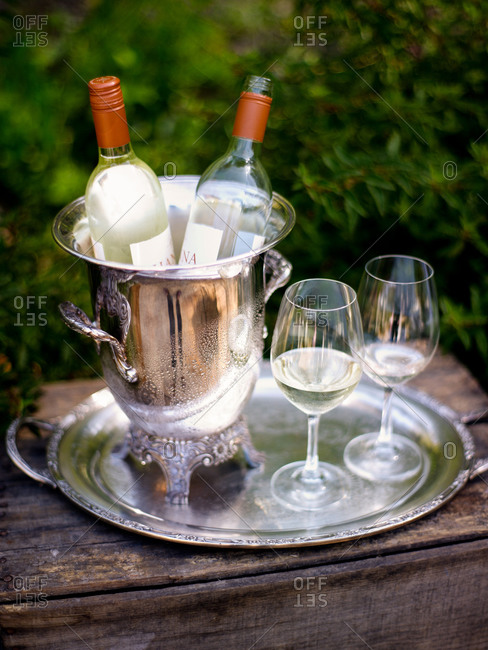 Two empty wine glasses in a champagne bucket and wine glasses