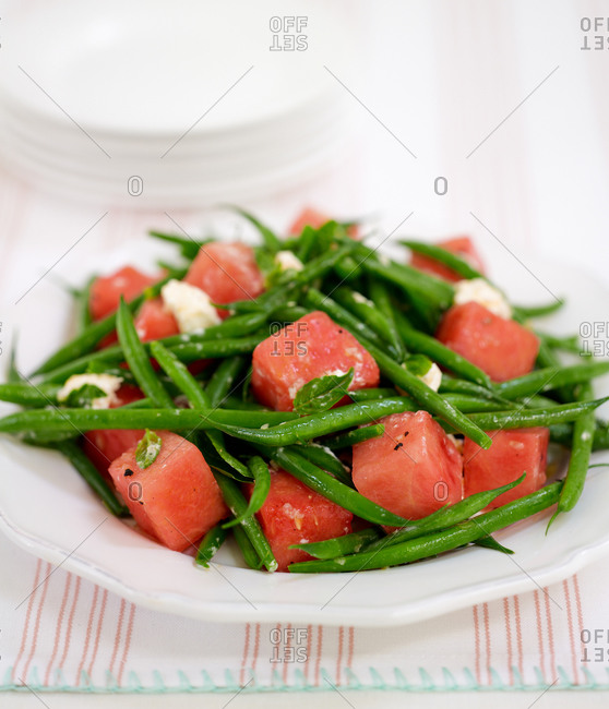 Close-up of a healthy salad: steamed green bean and melon cubes