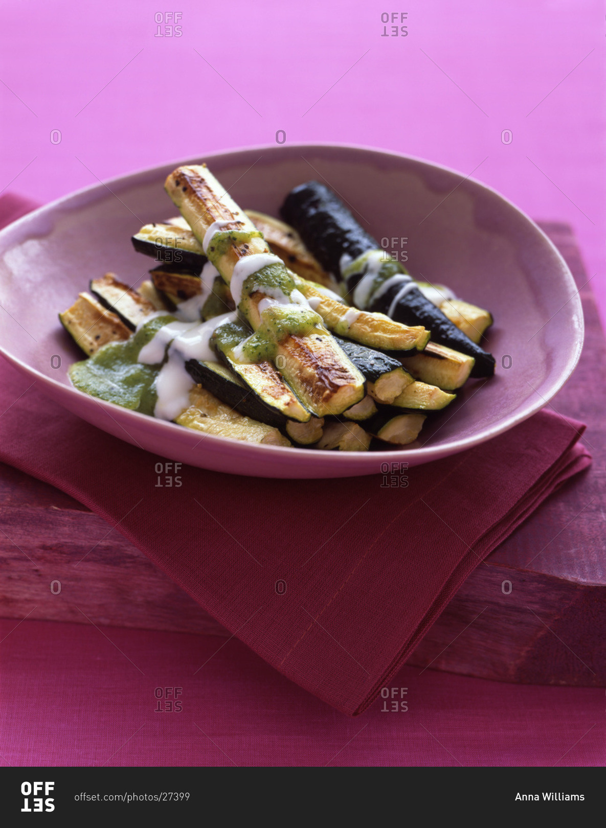 Roasted zucchini sticks drizzled with sauce for an appetizer or side dish