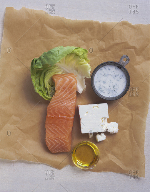 Composition with salmon, cheese and sauce displayed on textured paper