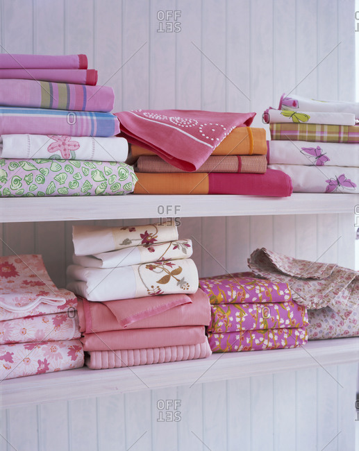 Textile of different colors and patterns arranged on shelves
