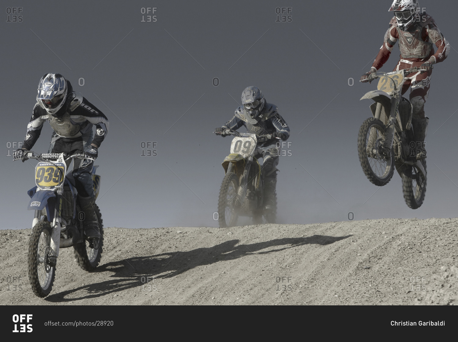 Motorcycle racers kicking up clouds of dust during race