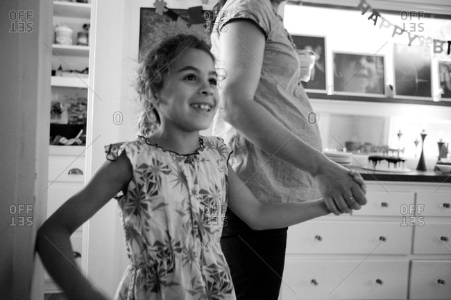 Surprised little girl standing with her mother in dining room