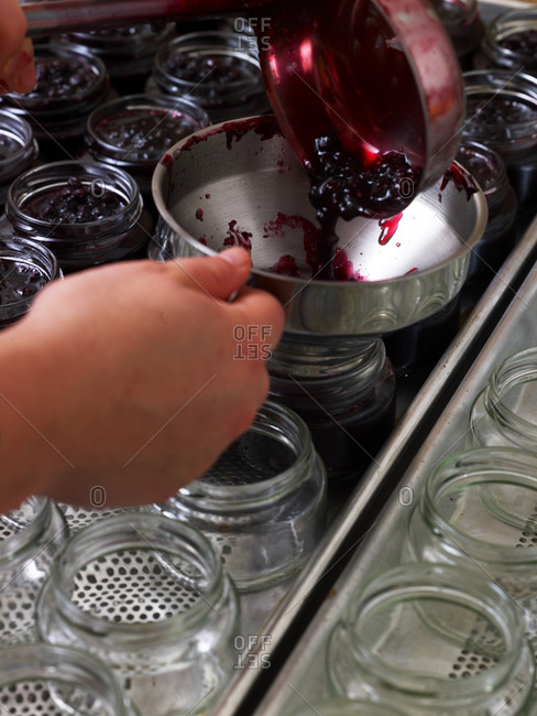 Filling cherry jam into glass jars